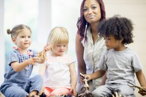 Head Start teacher working with three energetic toddlers