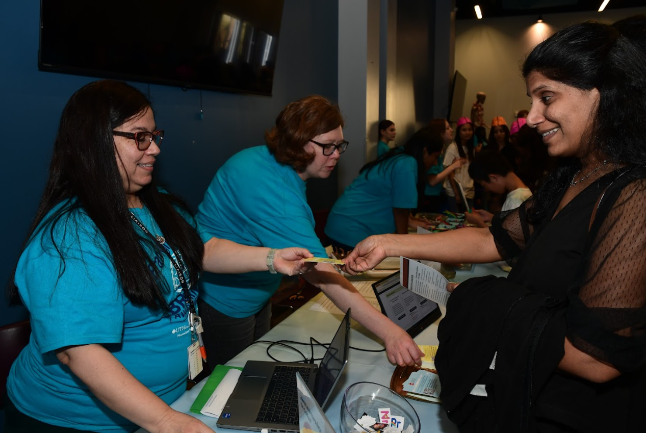 CLI employees greeting a parent at the 2026 Brain Night for Kids family event.
