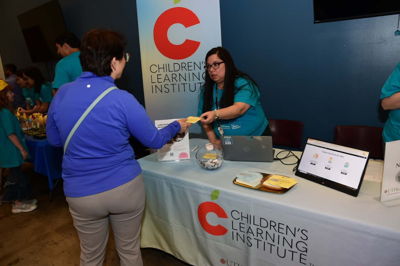CLI employee greeting a parent at the 2026 Brain Night for Kids family event.